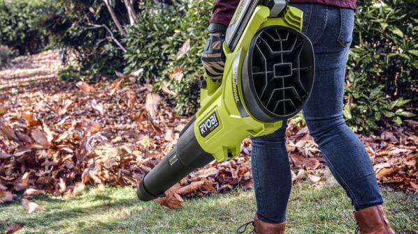 person using 40V Ryobi blower on leaves in yard