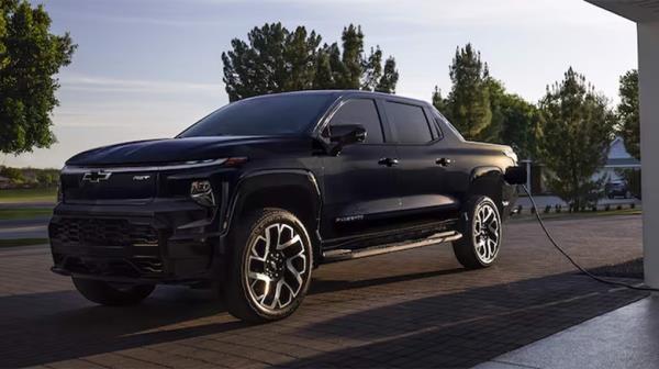 A black Chevy Silverado EV being charged